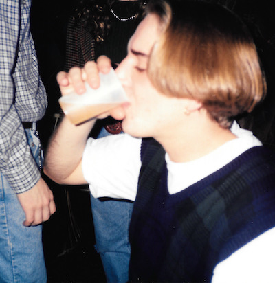 Young Bones slugging a Whiskey Sour or a beer or something that is probably warm and stale